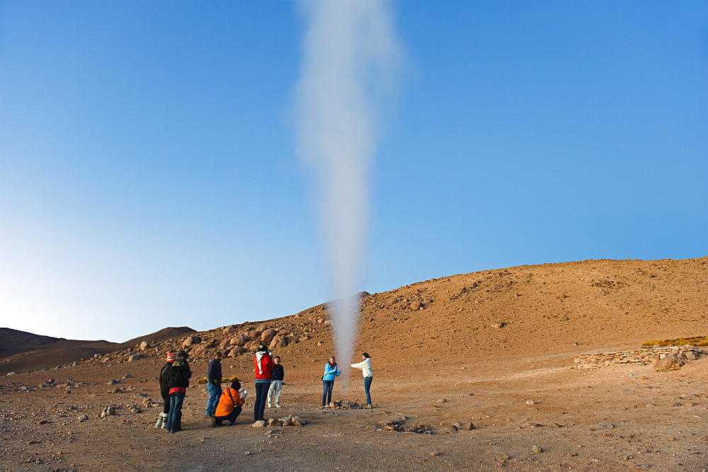 Tourists looking at geysers in Eduardo Avaroa Andean National Reserve, Bolivia, South America