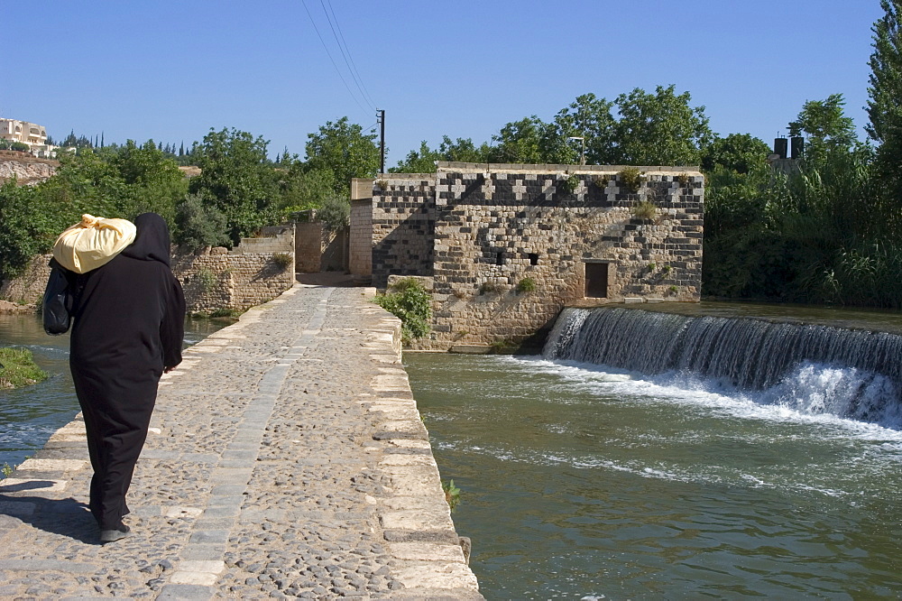 Woman crossing Orontes River, Hama, Syria, Middle East