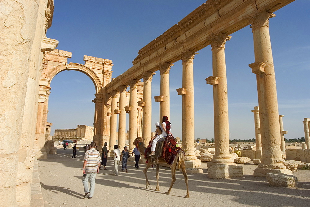 Tourist camel ride, monumental arch, archaelogical ruins, Palmyra, UNESCO World Heritage Site, Syria, Middle East