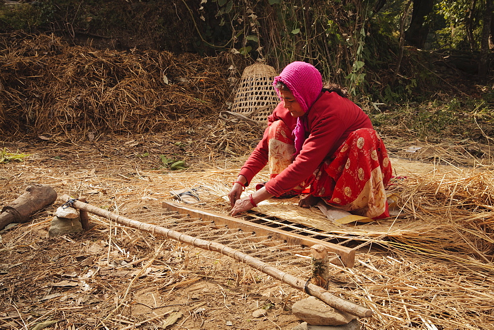 Local woman making traditional woven bed using grass, Pokhara, Nepal, Asia