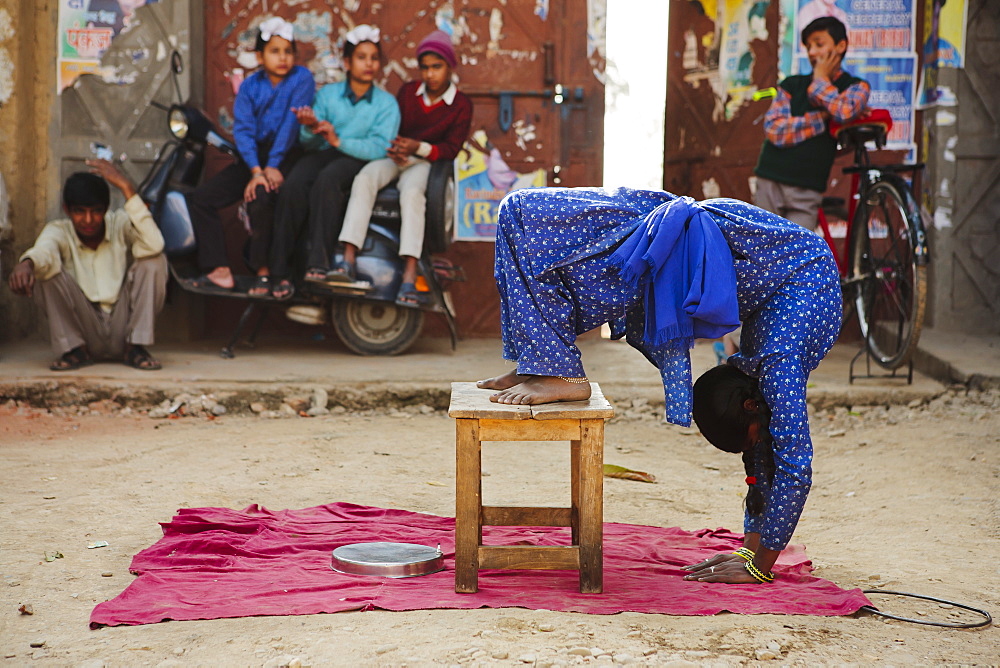 Professional contortionist street performer doing yoga tricks on side of road, Pinjore, Punjab, India, Asia