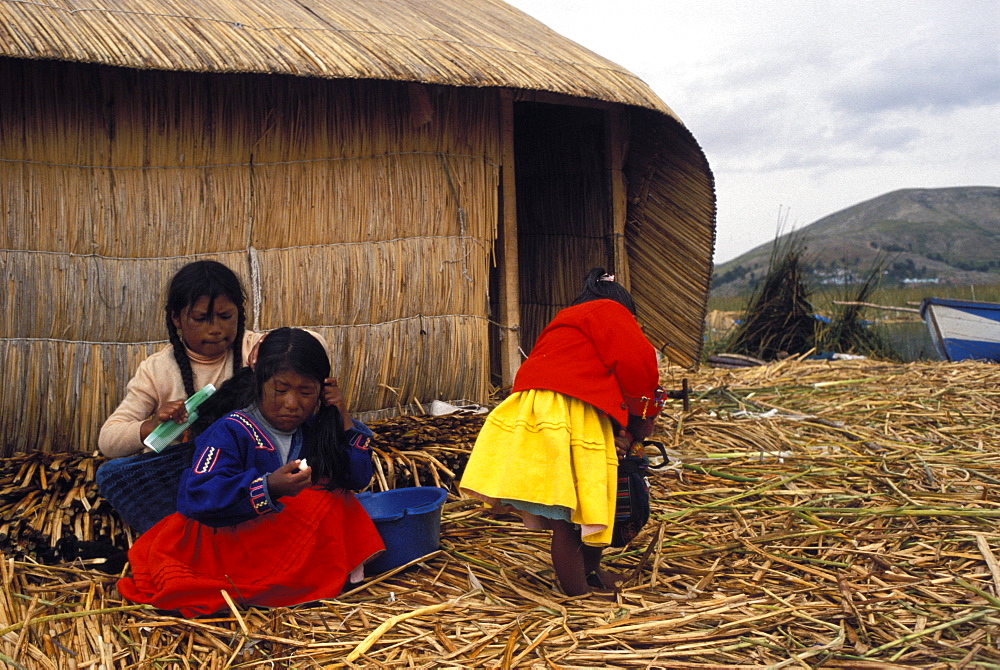 Small group of women and girls of the Uros people on the floating reed islands, Lake Titicaca, Peru, South America