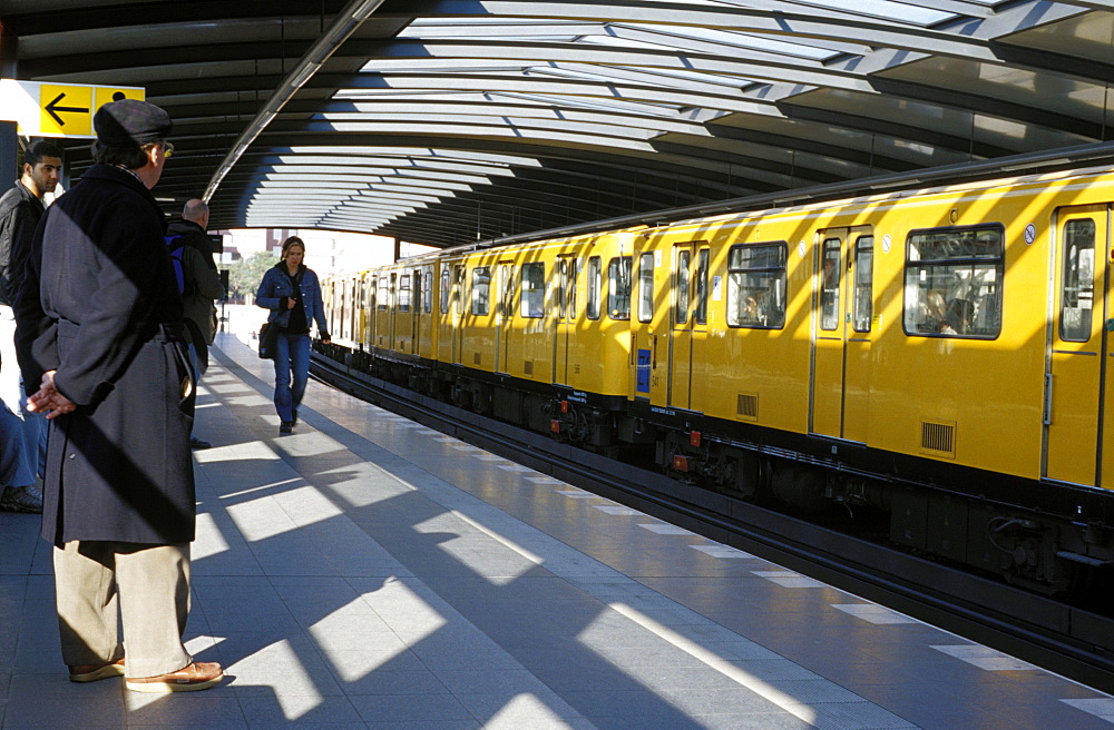 Passengers on the platform and a yellow train, Mendelsshon U-Bahn station, Berlin, Germany, Europe