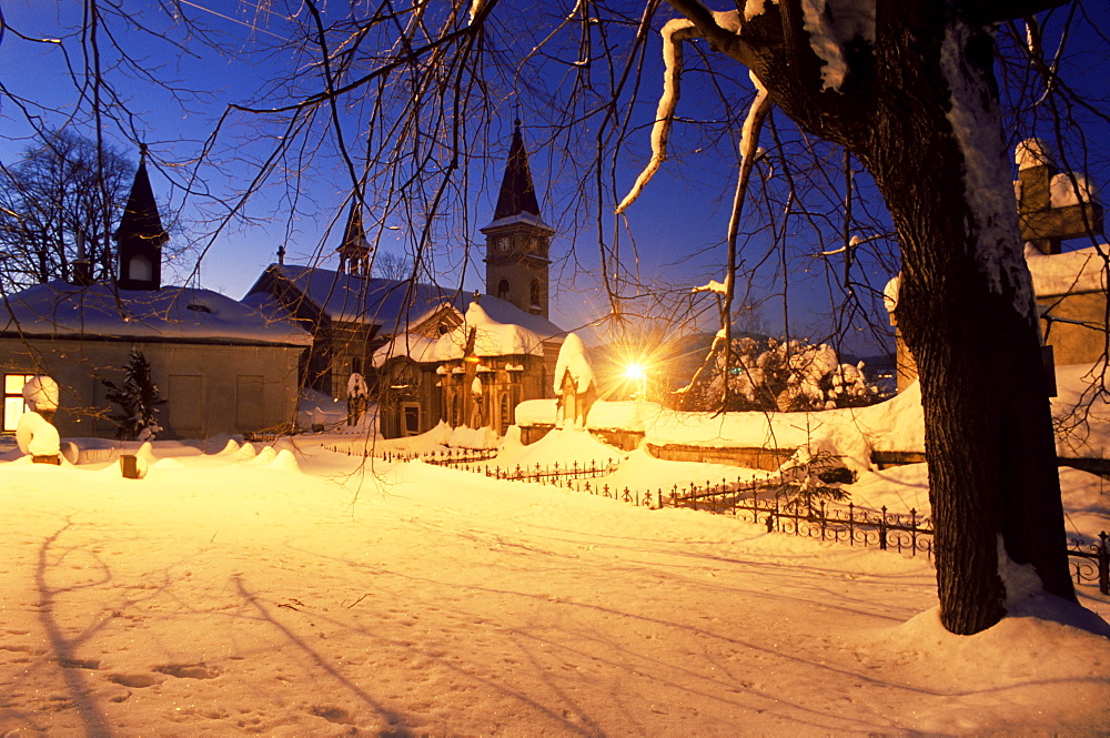 Snow-covered graveyard and Catholic church in village of Luceny nad Nisou, Jizerske Mountains, Luceny nad Nisou, Liberecko, Czech Republic, Europe