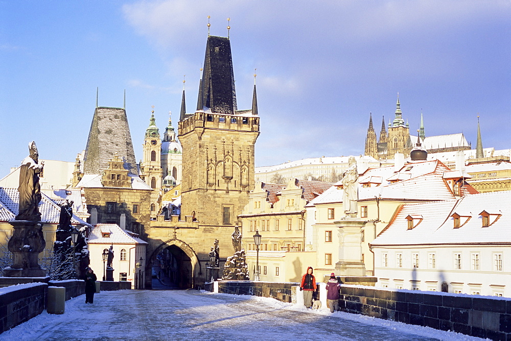 Snow-covered Gothic Charles bridge with Baroque statues, Romanesque and Gothic Malostranske bridge towers and Prague castle, Mala Strana, Prague, Czech Republic, Europe