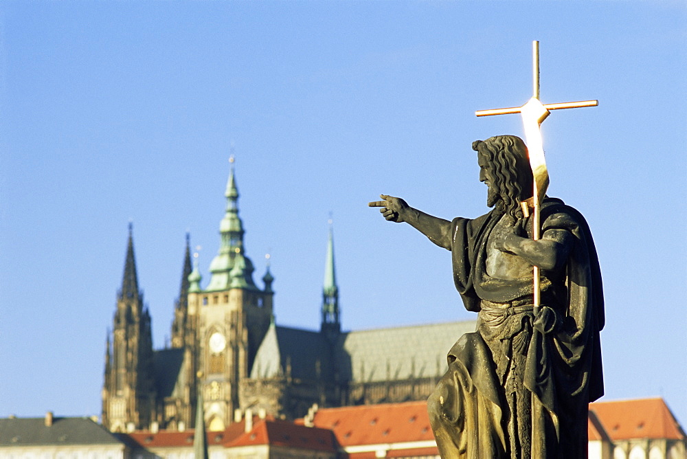 Statue of St. John the Baptist, dating from 1857, on Charles Bridge, pointing to Gothic St. Vitus Cathedral at Prague Castle, Stare Mesto, Prague, Czech Republic, Europe