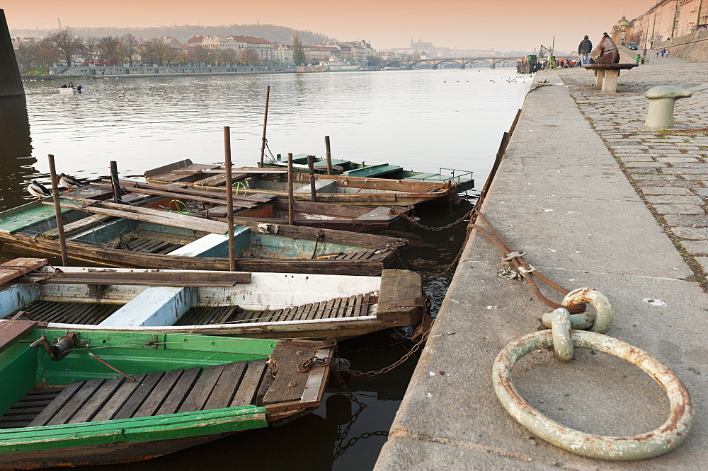 Fishing boats, ducks, Vltava River and Prague Castle during autumn at embankment below Rasinovo nabrezi, Vyton, Nove Mesto, Prague, Czech Republic, Europe