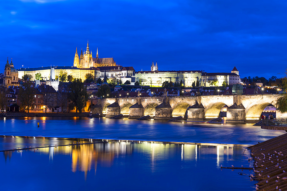 Prague Castle and Charles Bridge reflected in Vltava River at twilight, UNESCO World Heritage Site, Lesser Town (Mala Strana), Prague, Czechia, Europe