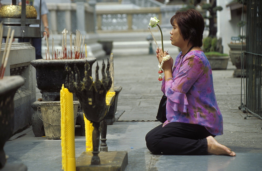 Thai Buddhist woman praying at temple, Wat Phra Kaew (Wat Phra Kaeo), Royal Palace, Bangkok, Thailand, Southeast Asia, Asia