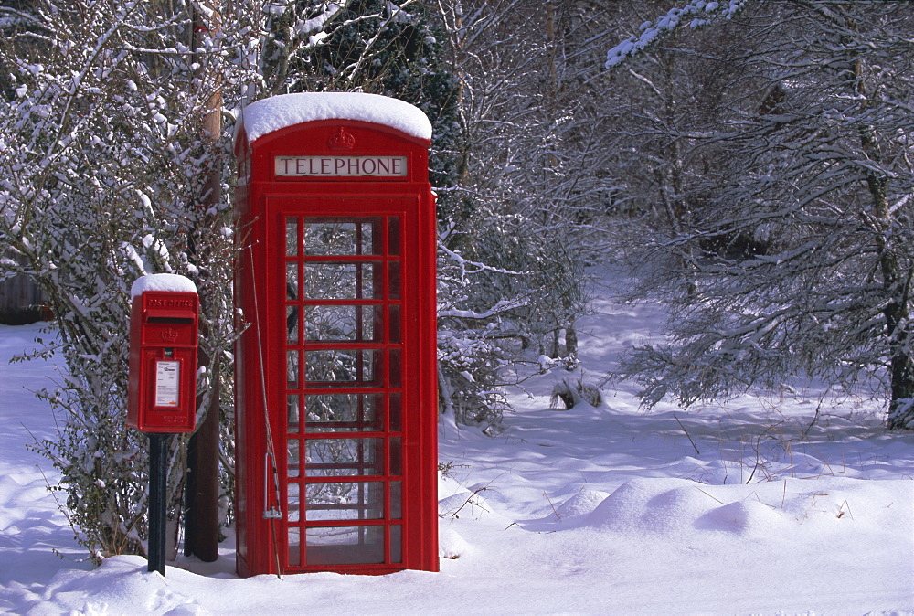 Red letterbox and telephone box in the snow, Highlands, Scotland, UK, Europe