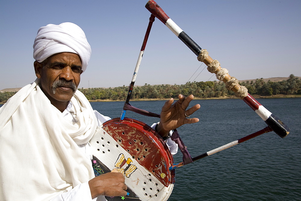 Nubian with traditional guitar beside the River Nile, Egypt, North Africa, Africa