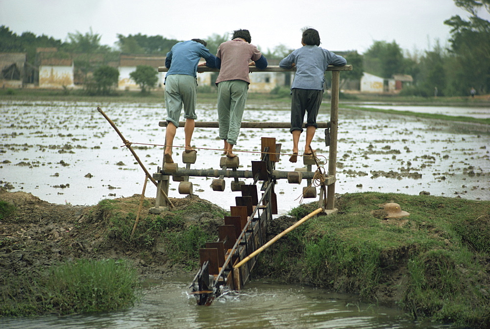 Three women working irrigation mill, near Canton, China, Asia