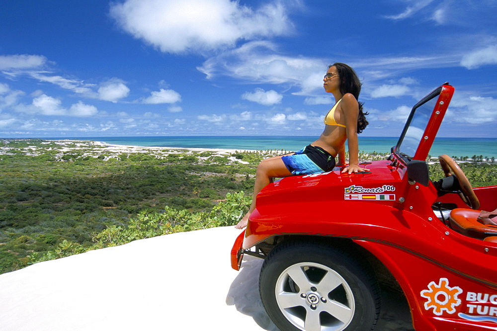 Young woman sitting on dune buggy, Pitangui, Natal, Rio Grande do Norte state, Brazil, South America