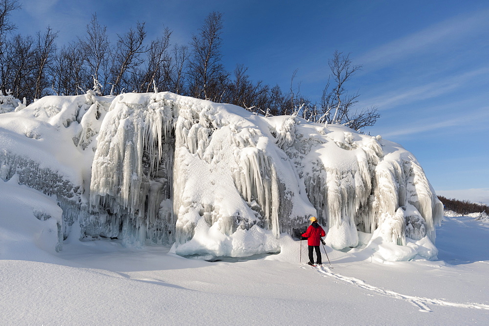 A woman looking at spectacular ice formations, Tornetrask Lake, Abisko National Park, Sweden, Scandinavia, Europe