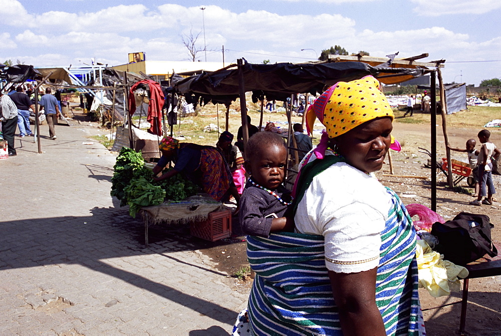 Woman carrying small child on her back, Soweto, Johannesburg, South Africa, Africa