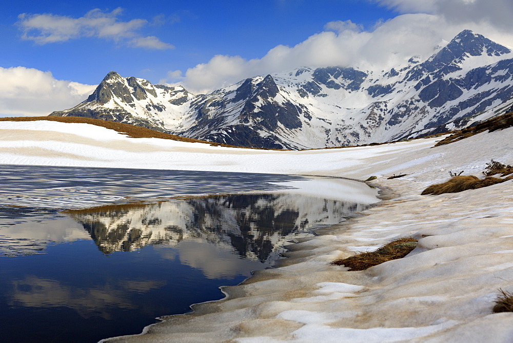 Lago degli Andossi melting in late spring, with Suretta Group reflecting, Vall Spluga, Lombardy, Italy, Italy