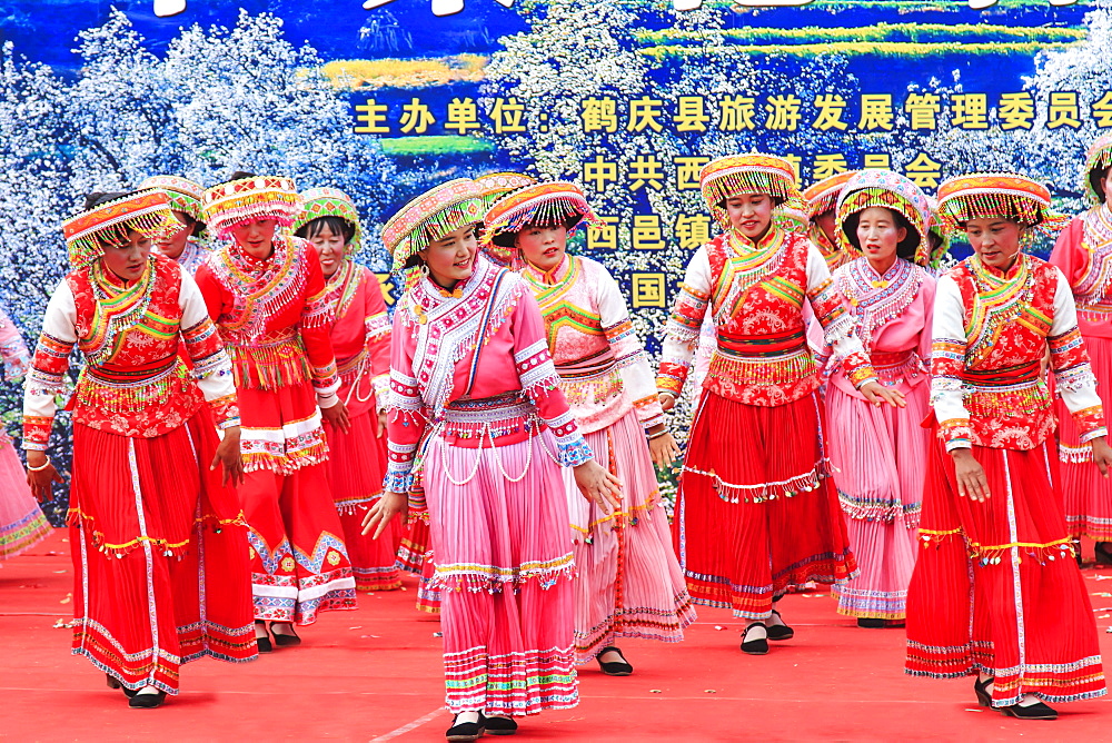 Chinese women dressed with traditional clothing dancing and singing during the Heqing Qifeng Pear Flower festival, China