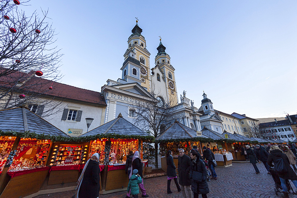 The Christmas Market in Brixen (also called  Bressanone or Persenon) on the medieval market place Europe, the steeples of Brixen cathedral in the background. Europe, Central Europe, Italy, South Tyrol, December