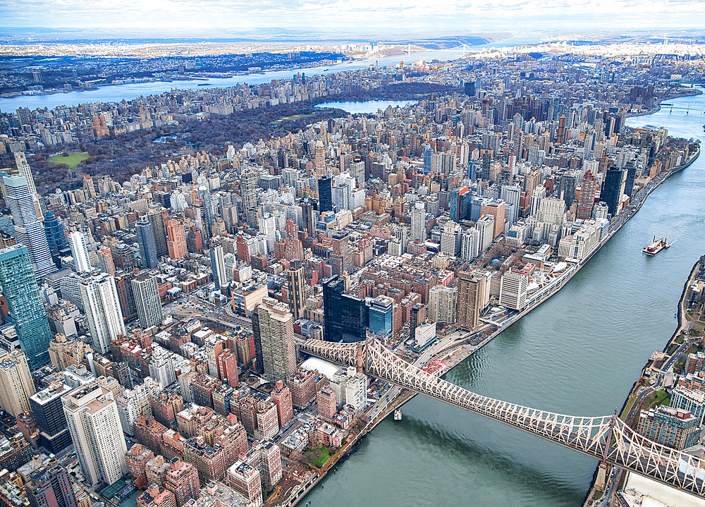 New York City from helicopter point of view. Queensboro Bridge with Manhattan skyscrapers on a cloudy day.