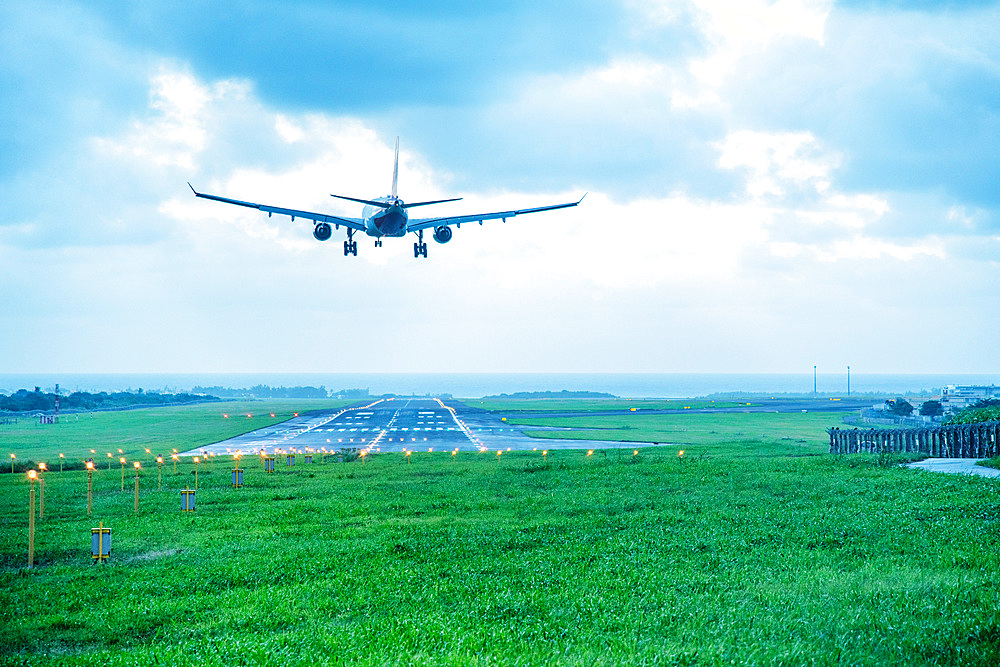 Giant aircraft landing at the airport with runway in the background. Back view.