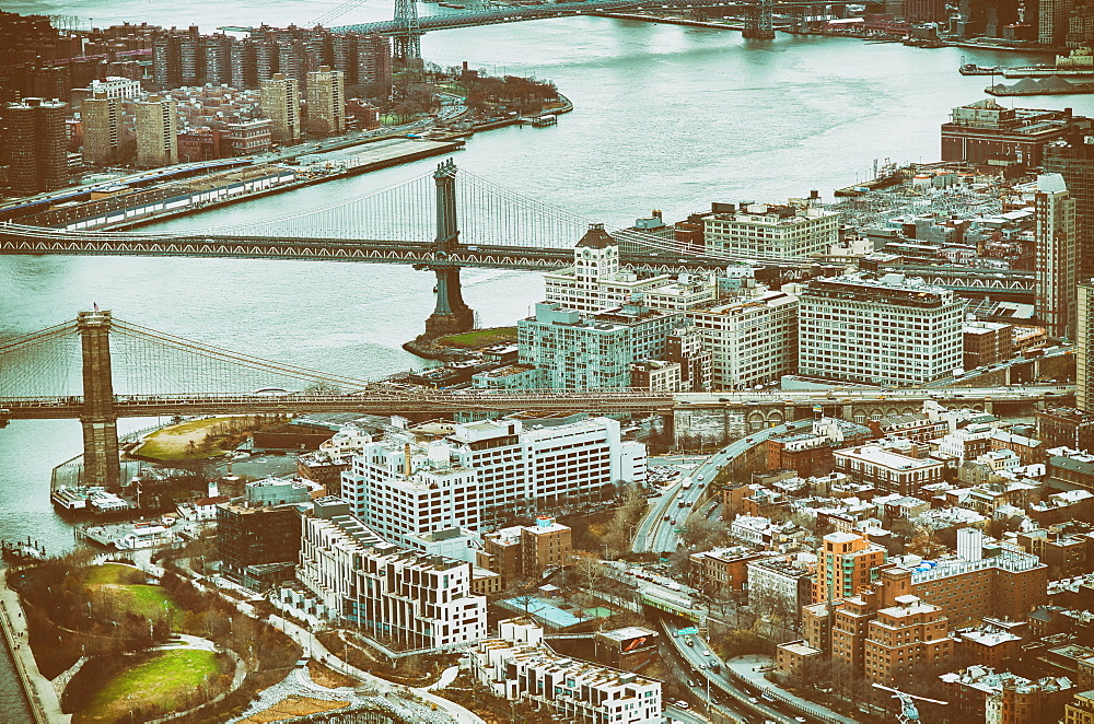 New York City from helicopter point of view. Brooklyn and Manhattan Bridges with Manhattan skyscrapers on a cloudy day.