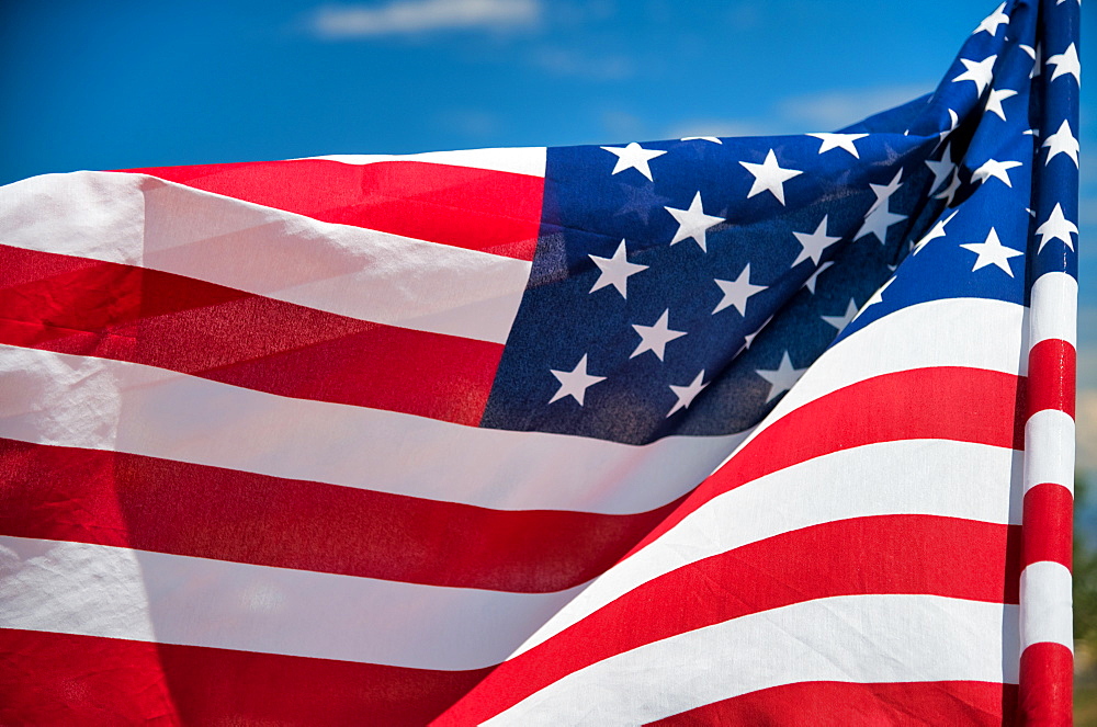 Waving American Flag on blue sky background.