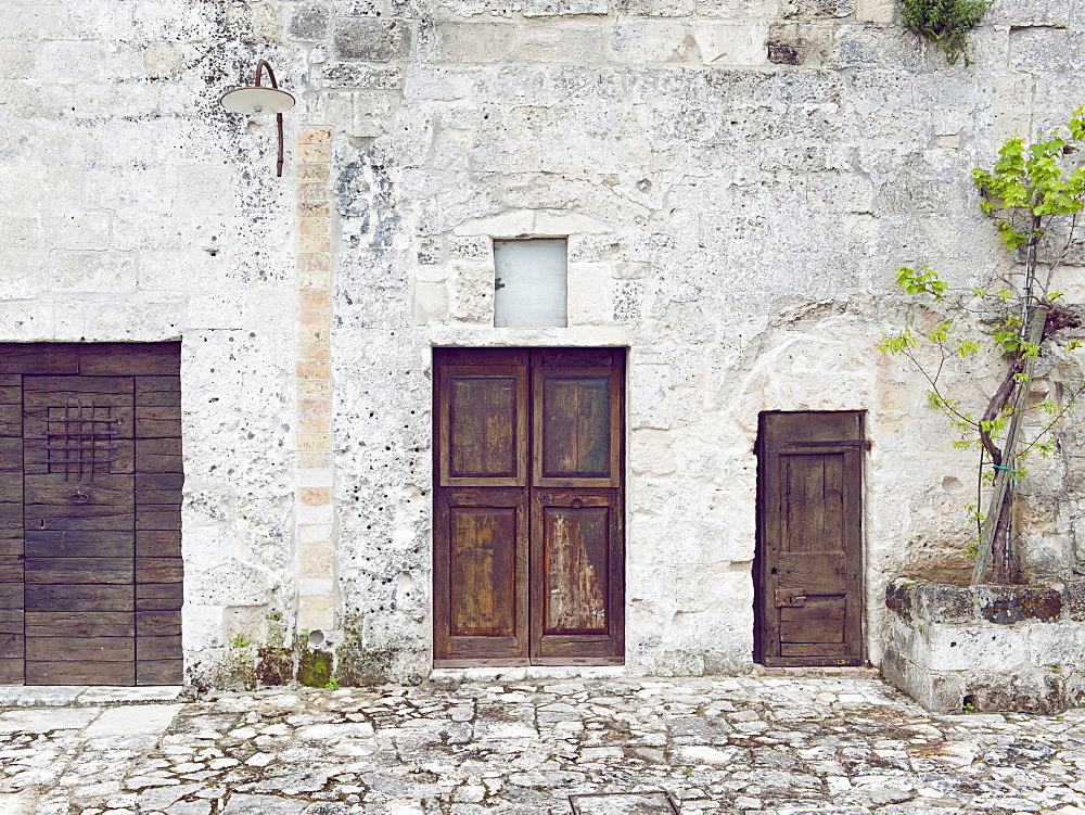 Ancient entrance gates to the cave houses in Matera into the Sassi. The Sassi di Matera are ancient cave dwellings in the Italian city of Matera, Basilicata. Situated in the old town, they are composed of the Sasso Caveoso and the later Sasso Barisano. Matera, Basilicata, Italy, Europe