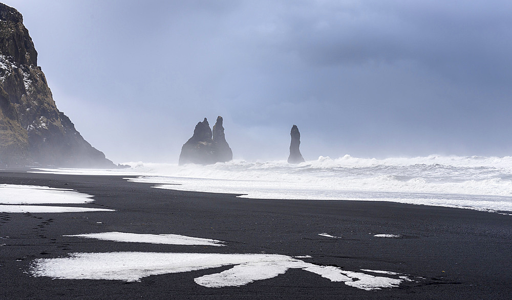 The coast of the north atlantic near Vik y Myrdal during winter. Black volcanic beach Reynisfjara with the sea stacks Reynisdrangar. Europe, Northern Europe, Scandinavia, Iceland, February