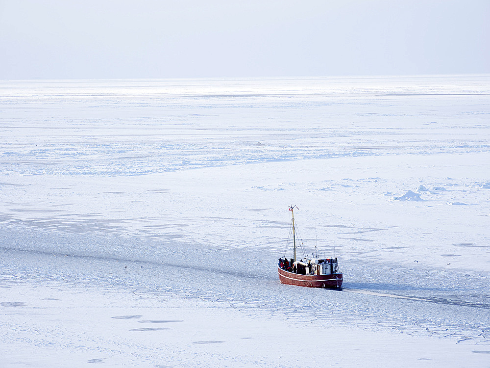 Boat on the frozen Disko Bay with icebergs at the Ilulissat Icefjord . The icefjord is listed as UNESCO world heritage. America, North America, Greenland, Denmark