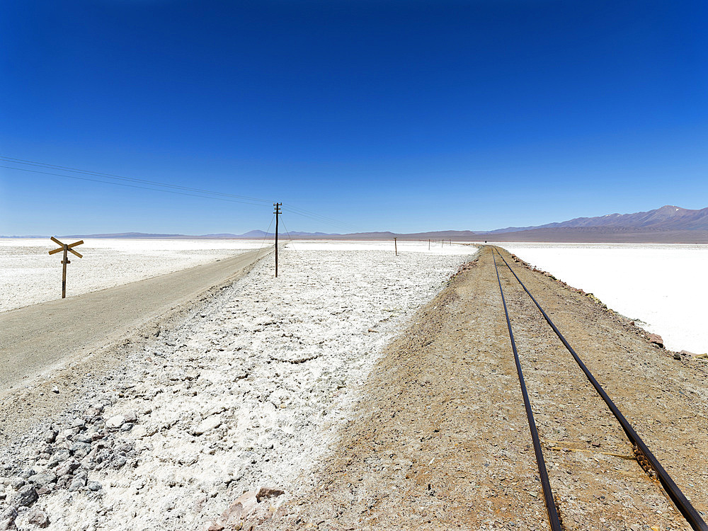 The salt flats Salar de Pocitos in the Argentinian Altiplano. Routa 27 and the railway Salta - Antofagasta is crossing the salt flats. South America, Argentina