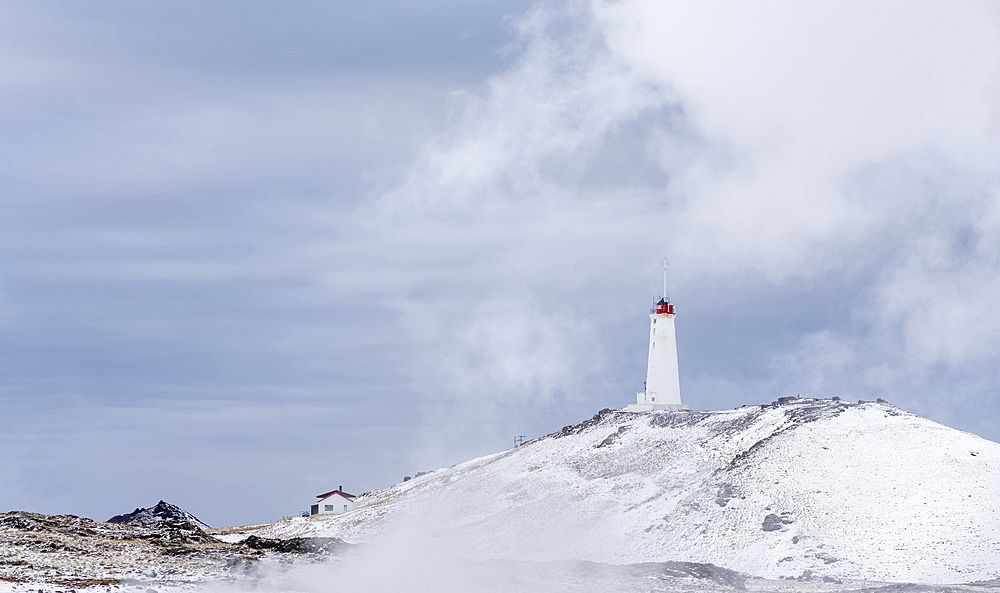 Reykjanesviti lighthouse with steam hovering over the hot springs of the geothermal area Gunnuhver and teh geothermal power plant Sudurnes. europe, northern europe, iceland, February