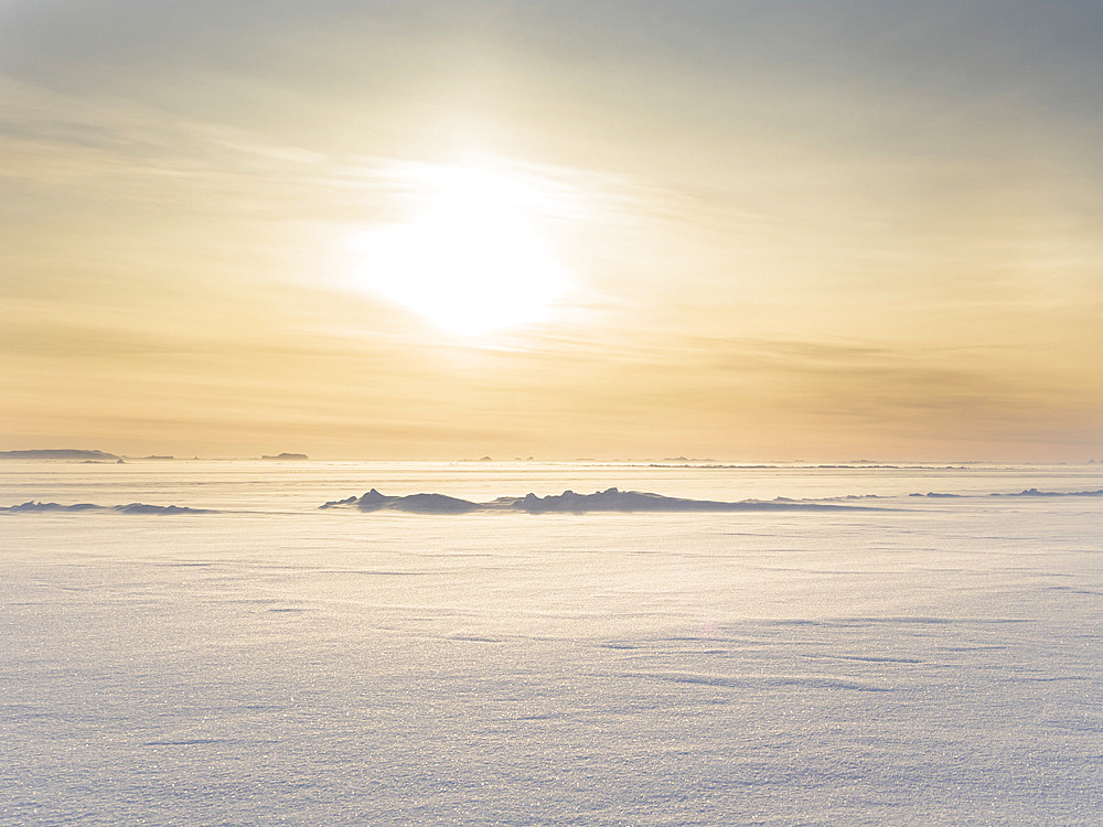 Sunset over the stormy and frozen Melville Bay, part of the Baffin Bay, near Kullorsuaq in the far north of West Greenland.