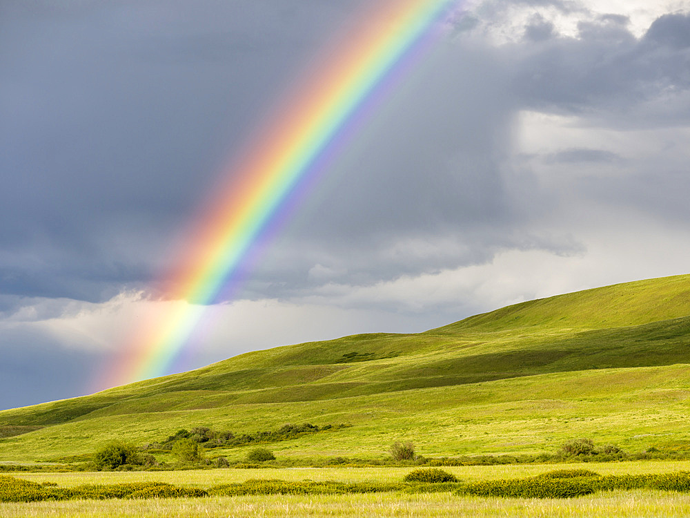 Rainbow over the Suusamyr plain, a high valley in Tien Shan Mountains. Asia, central Asia, Kyrgyzstan