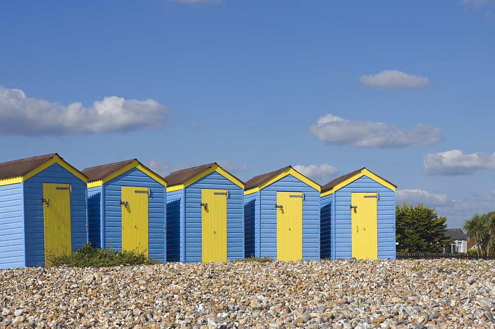 Five blue beach huts with yellow doors, Littlehampton, West Sussex, England, United Kingdom, Europe