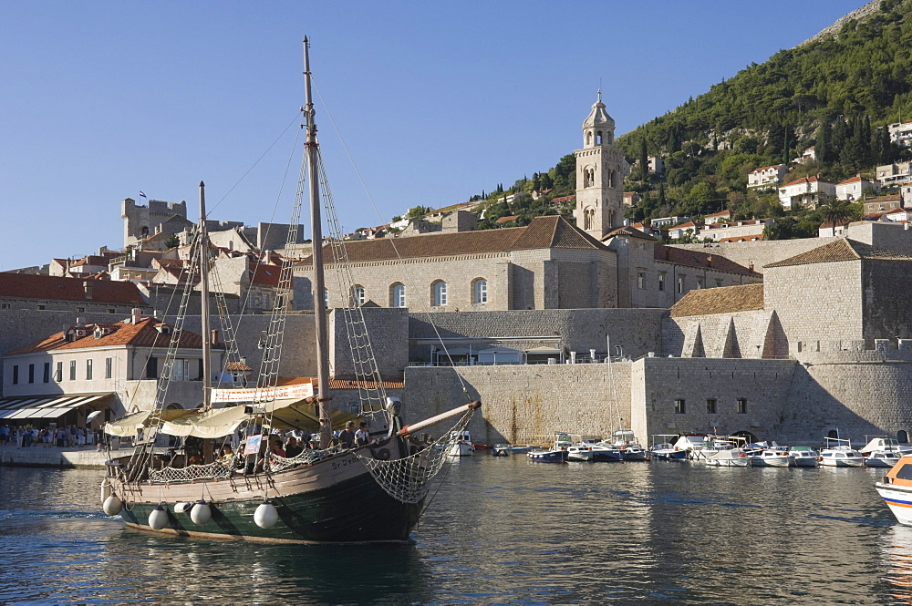 Tourist boat in the old harbour with the bell tower of the Franciscan Monastery in the background, Old Town, Dubrovnik, UNESCO World Heritage Site, Croatia, Europe 