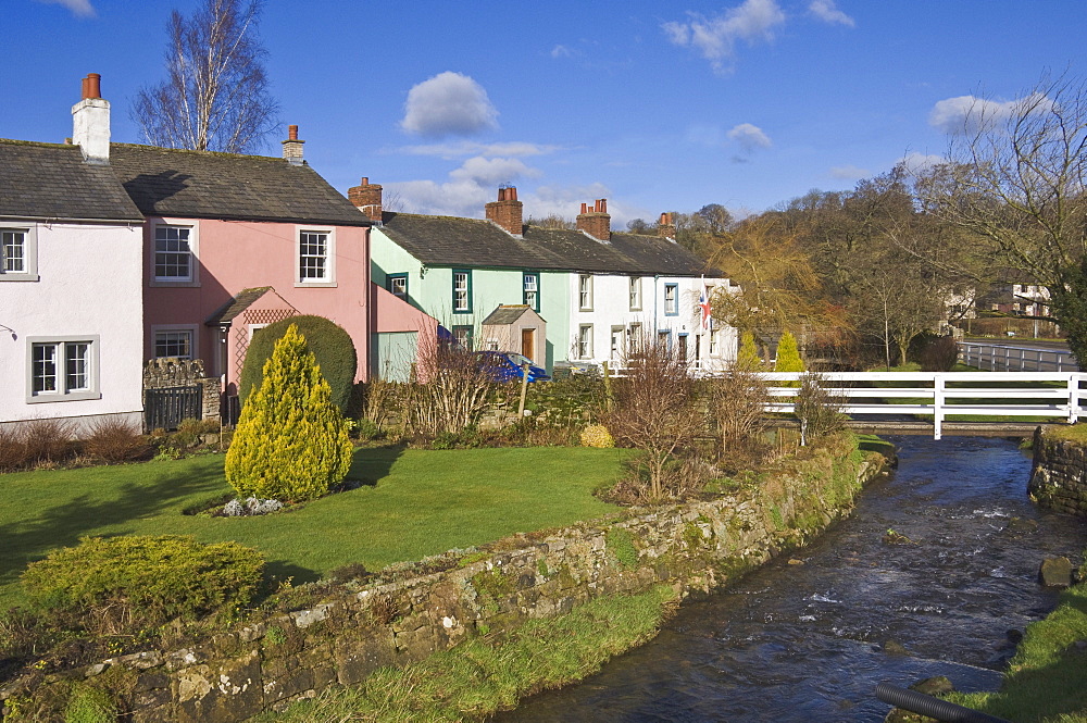 Pastel coloured cottages alongside the beck in Calthwaite, John Peel Country, Cumbria, England, United Kingdom, Europe 