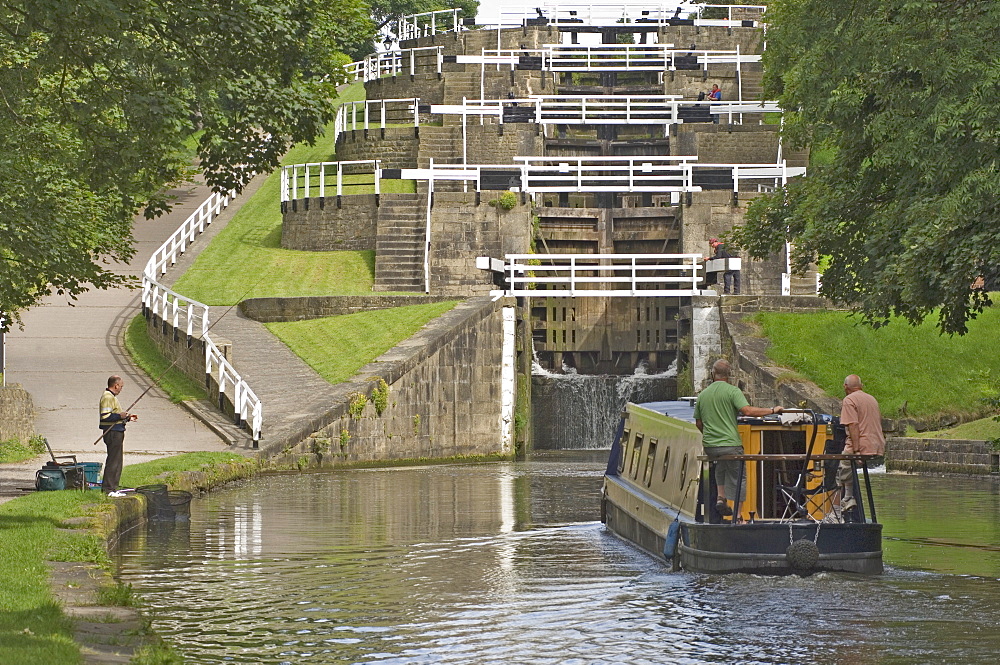 Narrow boat entering the bottom lock of the five lock ladder on the Liverpool Leeds canal, at Bingley, Yorkshire, England, United Kingdom, Europe