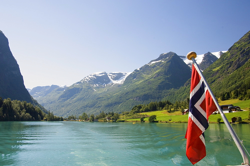 Sailing on the green lake and Norwegian flag, Olden, Fjordland, Norway, Scandinavia, Europe