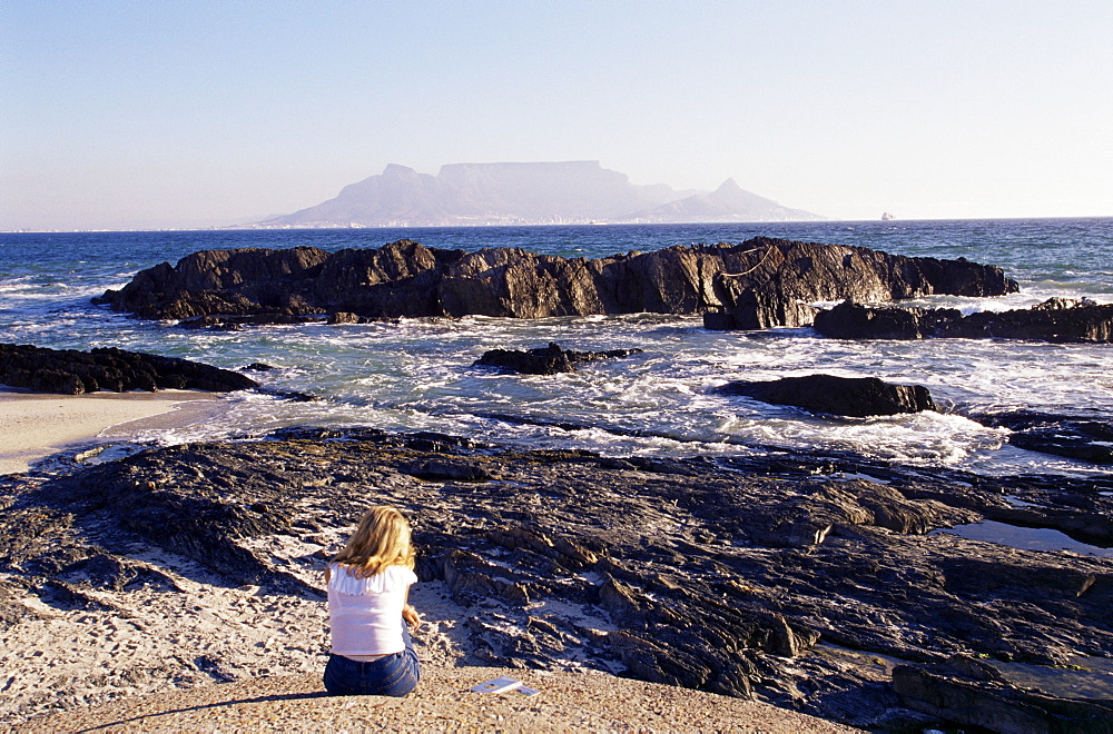 Woman on beach at Bloubergstrand looking across to Table Mountain, Cape Town, South Africa, Africa