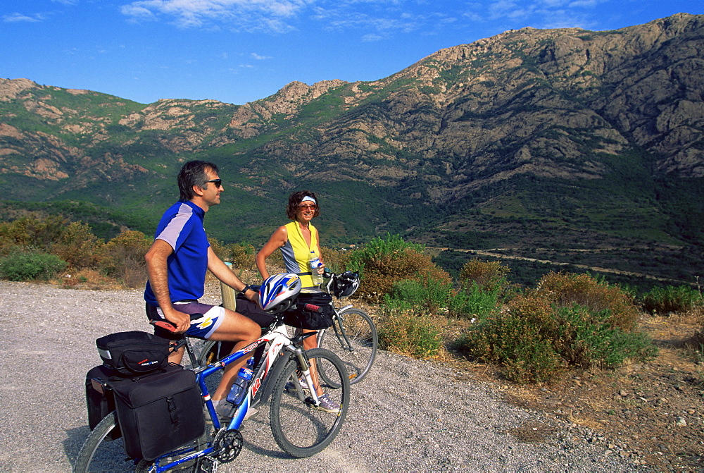 Cyclists near Galeria, Corsica, France, Europe