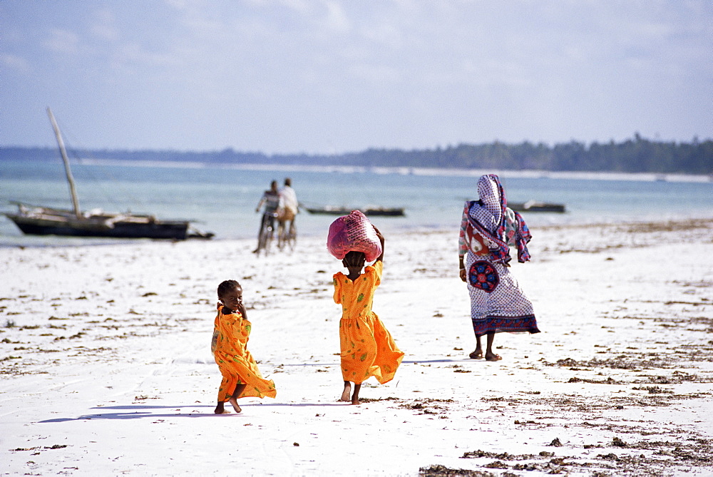 Young girls and their mother walking along the beach, Zanzibar, Tanzania, East Africa, Africa