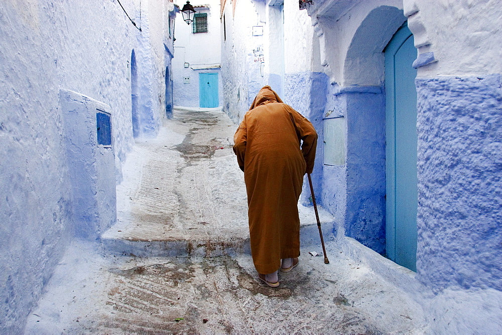 Old man walking in a typical street in Chefchaouen, Rif mountains region, Morocco, North Africa, Africa