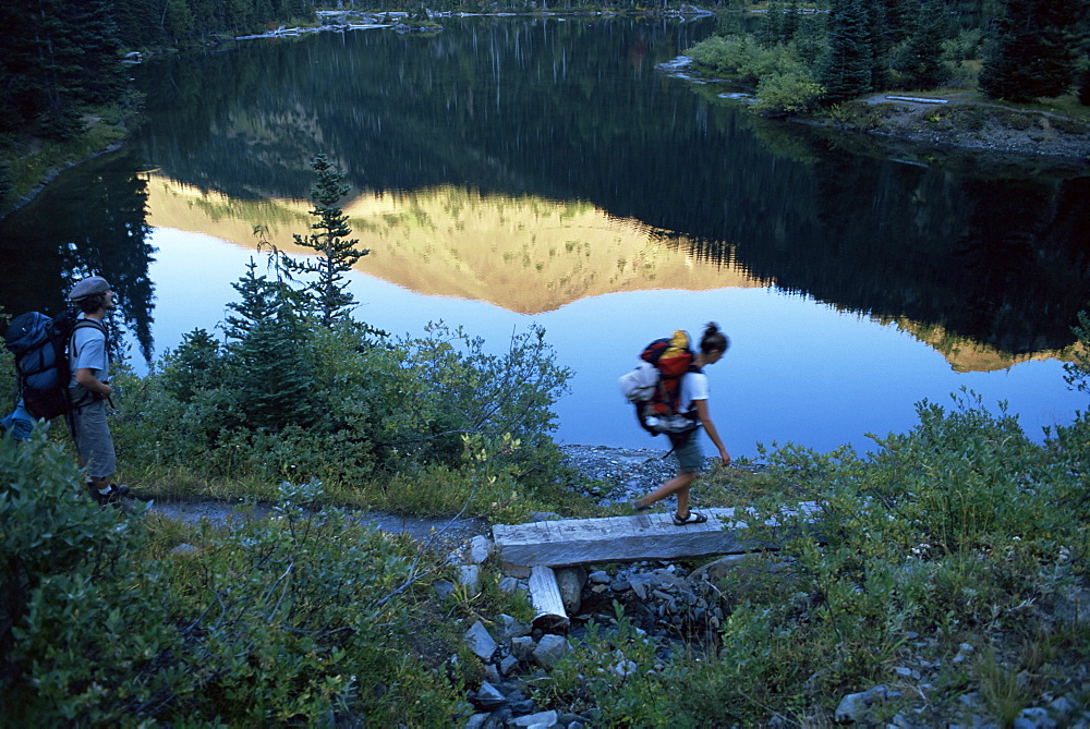 Backpacker crossing bridge, Olympic National Park, UNESCO World Heritage Site, Washington State, United States of America (U.S.A.), North America