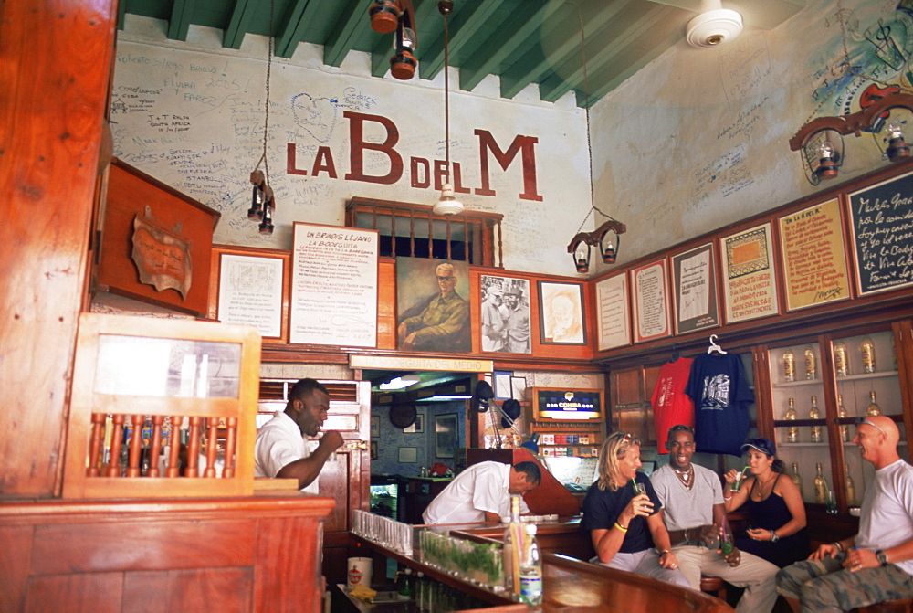 Tourists enjoy mojitos at the Bodegita del Medio, one of Havana's oldest bars, where the first mojito was made, and a favourite hangout of Ernest Hemingway, Havana, Cuba, West Indies, Central America