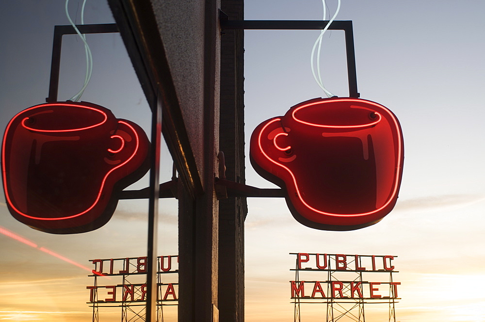 Neon coffee mug reflected in coffee shop window with the Pike Place Market behind, Seattle, Washington State, United States of America, North America