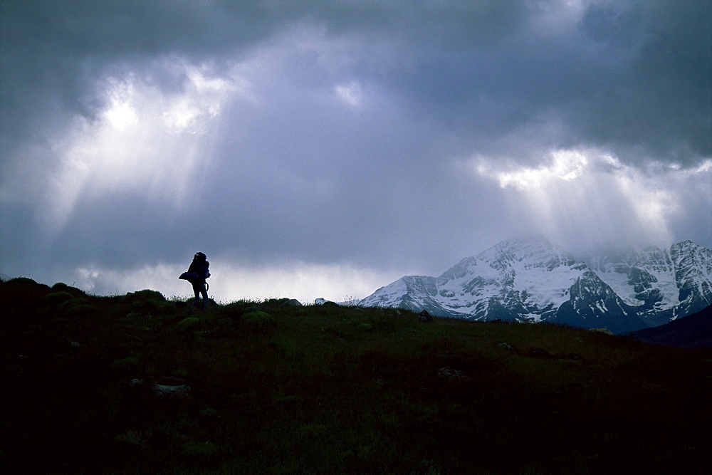 Silhouette of backpacker making way over pass in the Torres Circuit hike, Torres del Paine National Park, Chile, South America