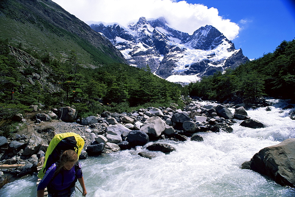 Backpacker crossing bridge in the Valle Frances, Torres del Paine National Park, Chile, South America