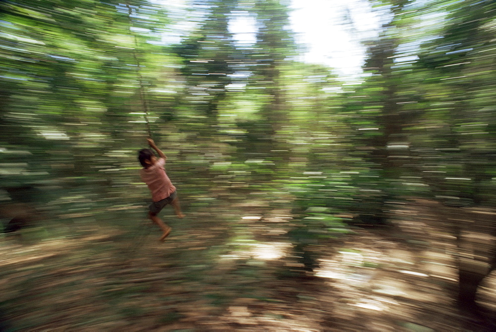 Local boy swings on vine, Corcovado National Park, Peninsula de Osa, Costa Rica, Central America