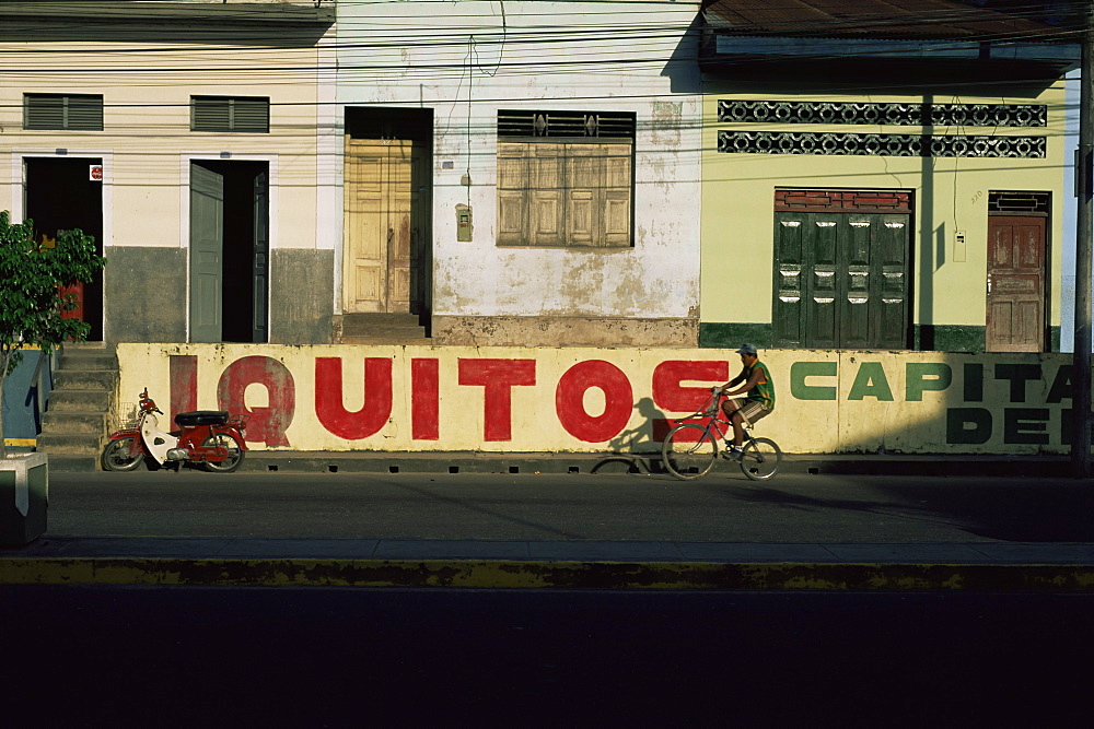 Bicycle cruises past homes, Iquitos, Peru, South America