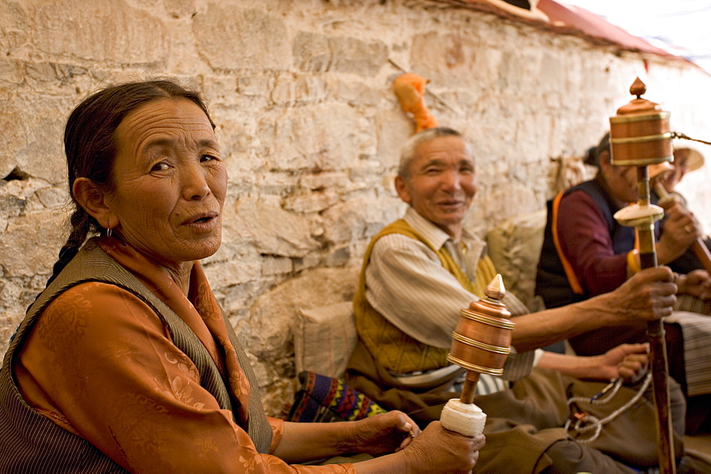 Spinning prayer wheels under a canopy to keep the sun off, on a monastery roof in the Bharkor, Lhasa, Tibet, China, Asia